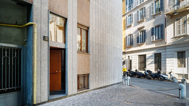 A narrow street with a building featuring a wooden door and a number '5' sign. - Orti - Modern Apartment Porta Romana (Milan)