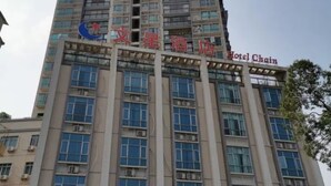 Un grand immeuble abritant un hôtel, avec de nombreux étages, de grandes fenêtres et une enseigne bien visible indiquant qu’il fait partie d’une chaîne hôtelière.