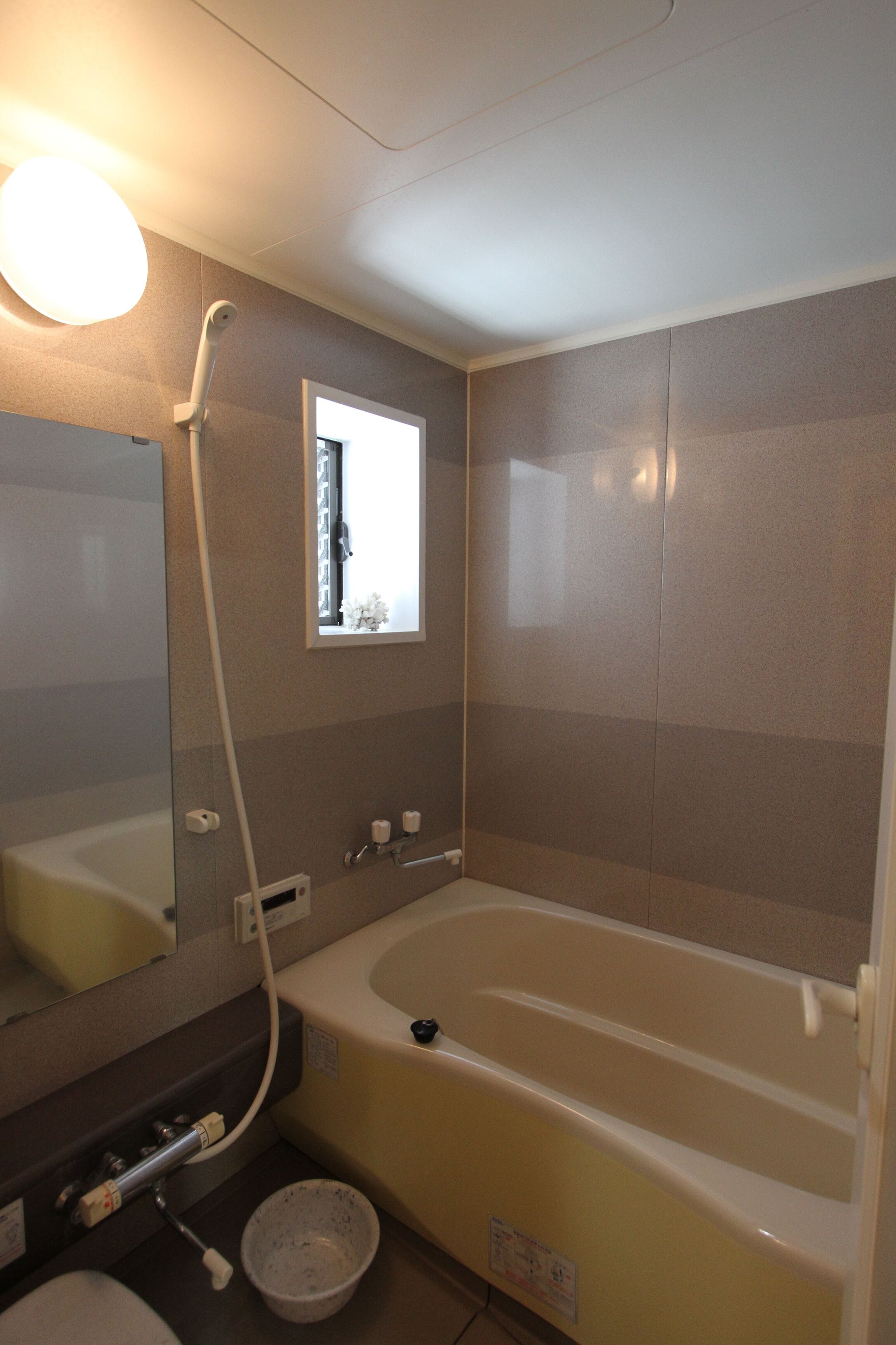 Une salle de bain avec une baignoire, un lavabo, un miroir et une fenêtre.