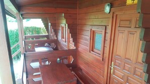 Una cabaña de madera con comedor que incluye una mesa y bancos de madera.