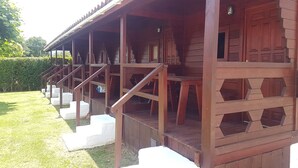 Una construcción de madera con un porche cubierto y escalones que conducen a una puerta numerada con el número 1.