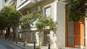 A building with a wooden door, a balcony, and a tree in front. - Modern Elegant Apartment at Kolonaki (Athina)