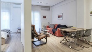 A modern living room with a sofa, a dining table with chairs, a coffee table, and a chair. - Modern Elegant Apartment at Kolonaki (Athina)