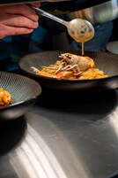 A person serving food from a bowl with a spoon.