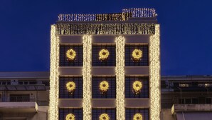 A hotel with multiple floors, each adorned with illuminated wreaths. - Heritage Hill (Athens)