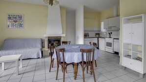 A compact living space with a dining area, kitchenette, and a fireplace.