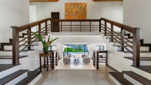 A spacious staircase with wooden railings leading to a balcony with a view. - Vista Mar (Koh Samui)