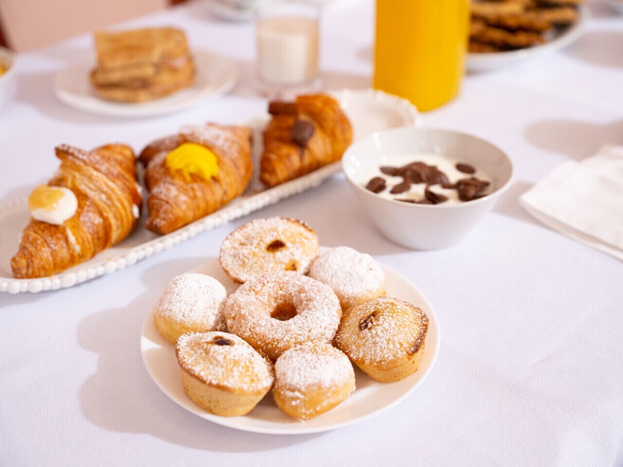 A table with pastries and a bowl of coffee beans.