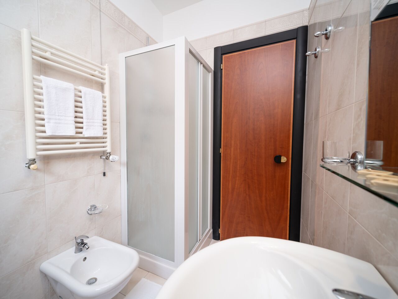 A modern bathroom with a toilet, bidet, and shower area.