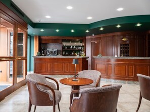 A bar area with wooden furniture and a counter. - Hotel San Pio (San Giovanni Rotondo)