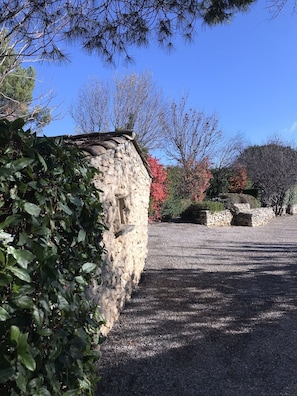 Eine Steinmauer mit einem Kiesweg, der zu einem Steinbau führt.