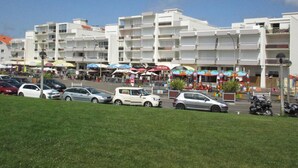 Un hôtel situé sur la côte, doté de nombreux balcons, d’un parking et offrant une vue sur la plage.
