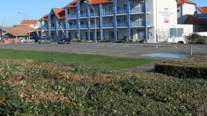 Un hotel de varios pisos con tejado de tejas rojas y balcones azules.