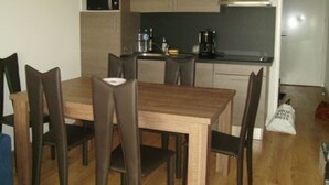 Cocina compacta con microondas, cafetera y armarios.