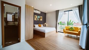 A modern bedroom with a bed, a sofa, and a balcony with a view. - BB's Cozy House & Apartment (Da Nang)