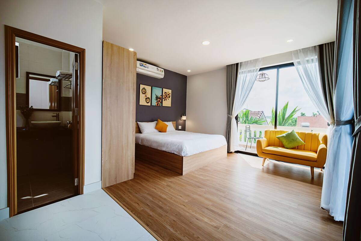 Une chambre moderne avec un lit, un canapé et un balcon offrant une vue agréable.