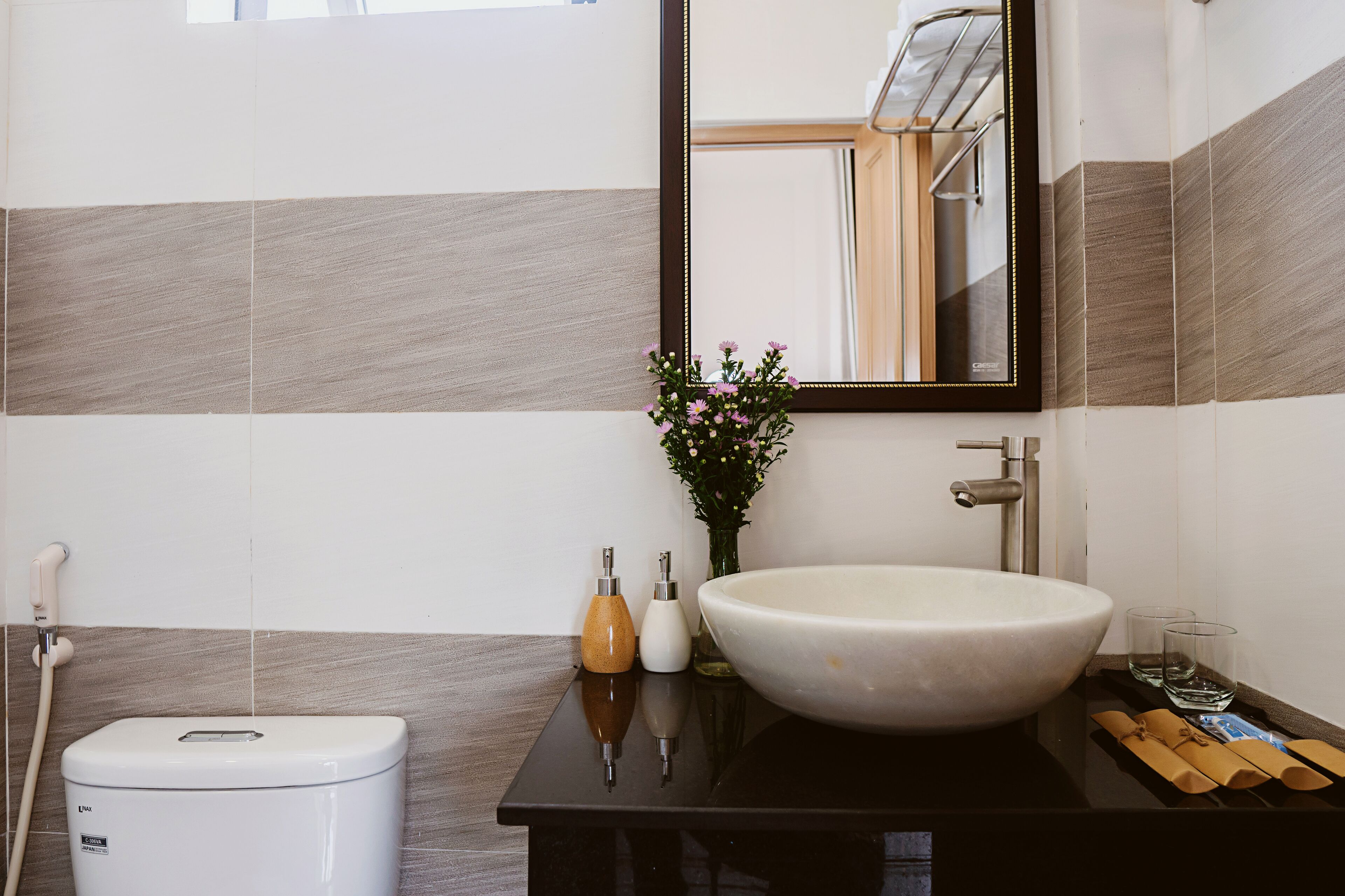 A bathroom with a white sink, a mirror, a toilet, and a shower.