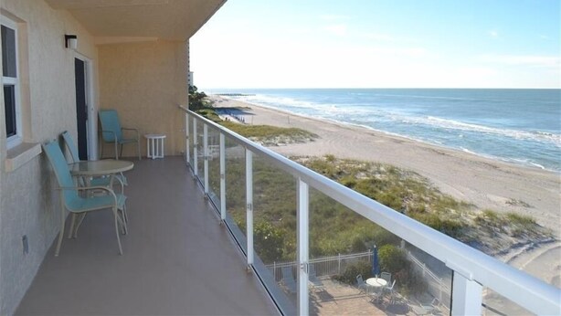 Un balcon avec vue sur la plage et l’océan.
