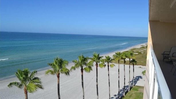 Ein Balkon mit Blick auf Strand und Meer.