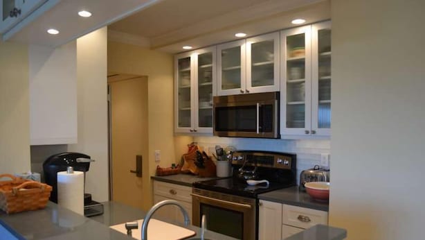 A modern kitchen with a built-in microwave, stainless steel appliances, and a large island with a sink. - Beachcomber unit 603 (Longboat Key)