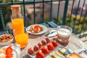 A breakfast table with a bottle of orange juice, a plate of strawberries, a glass of milk, and a bowl of cereal.