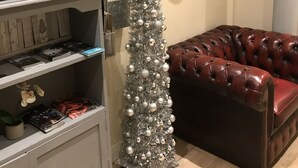 A Christmas tree with silver ornaments, a leather sofa, and a sign that reads "Merry Christmas." - Cultural quarter apartments (Leicester)