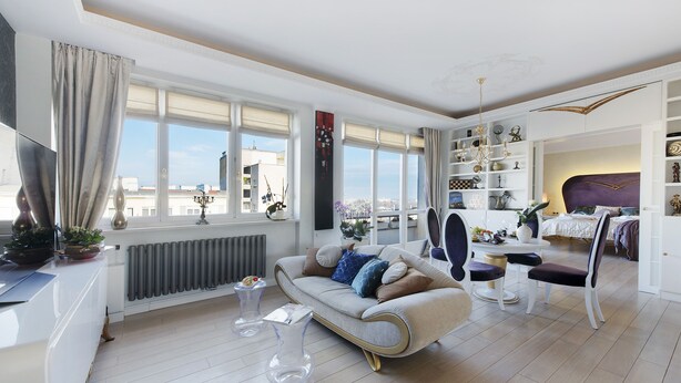 A modern living room with a sofa, clear glass coffee table, and a dining area with a table and chairs. - P&O Apartments Tamka 4 (Warsaw)