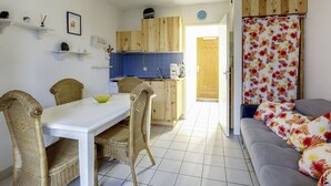 Un espace de vie compact comprenant un coin repas, une kitchenette et un canapé.