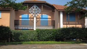 Un bâtiment à la façade marron, doté d’une porte bleue et d’un toit recouvert de tuiles.