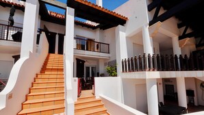 Ein mehrstöckiges Gebäude mit einer Treppe, die zu einem Balkon führt.