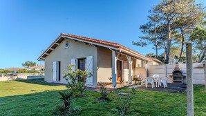 A house with a patio, outdoor seating, and a stone oven. - Spacious 3-BR House, Sleeps 7, Near Beach & Town, Large Yard, BBQ, Pet-Friendly (Biscarrosse Plage)