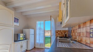 A kitchen with a refrigerator, microwave, and sink. - Spacious 3-BR House, Sleeps 7, Near Beach & Town, Large Yard, BBQ, Pet-Friendly (Biscarrosse Plage)