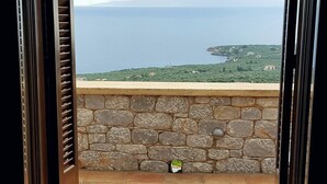 Un muro di pietra con vista sul paesaggio costiero.