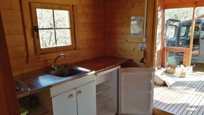 A compact kitchen with a sink, a window, and a refrigerator. - Chalet Aiguebelle  (Simiane-la-Rotonde)