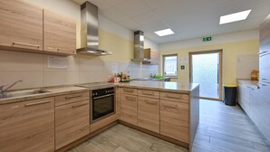 A modern kitchen with wooden cabinets, stainless steel appliances, and a large island.