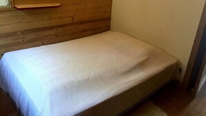 A small, single-bed room with a wooden wall and a heart-shaped decoration. - MEGEVE-T2-44M²-NEAR TOWN CENTER (Megève)