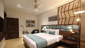 Un dormitorio moderno con una cama grande, cabecera de madera, una mesita de noche y una lámpara de pie.