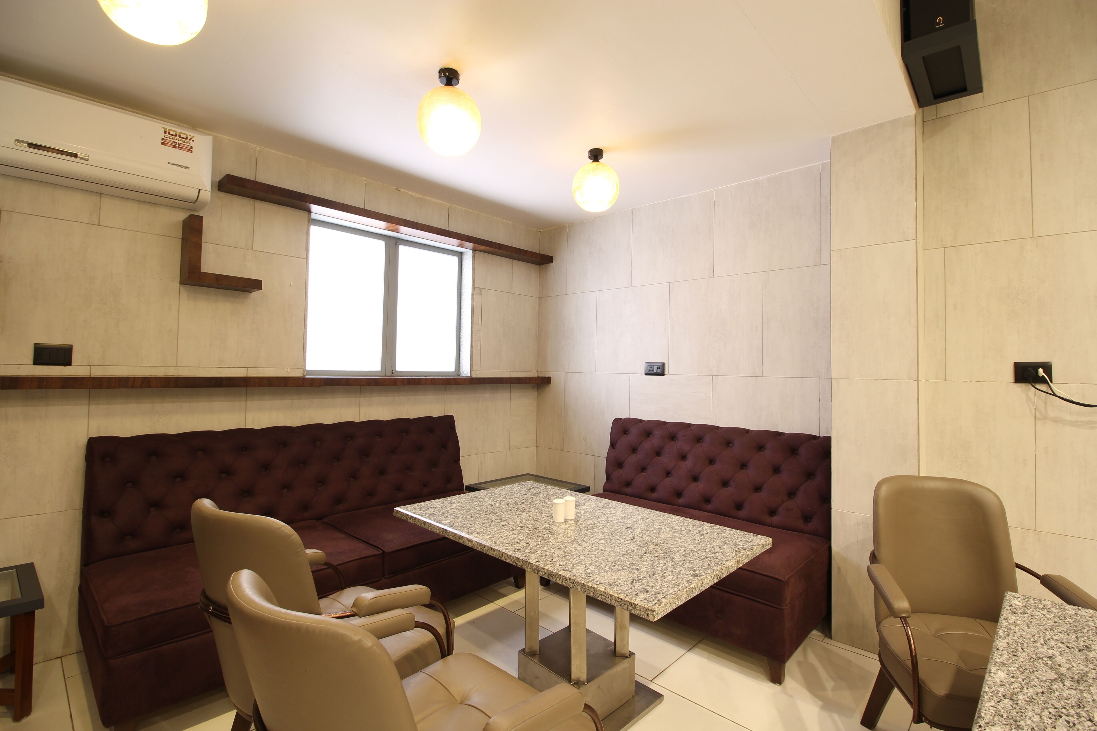 A modern living room with a marble table, two sofas, and a chair.