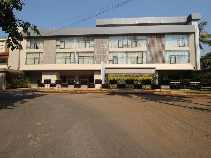 A modern multi-story building with a flat roof, large windows, and a central entrance.