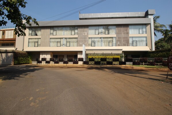 A modern multi-story building with a flat roof, large windows, and a central entrance.