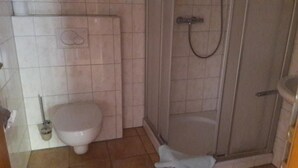 Un baño con inodoro, ducha y bidé.
