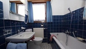 A bathroom with a sink, toilet, and bathtub. - Haus Aida (Saas-Fee)