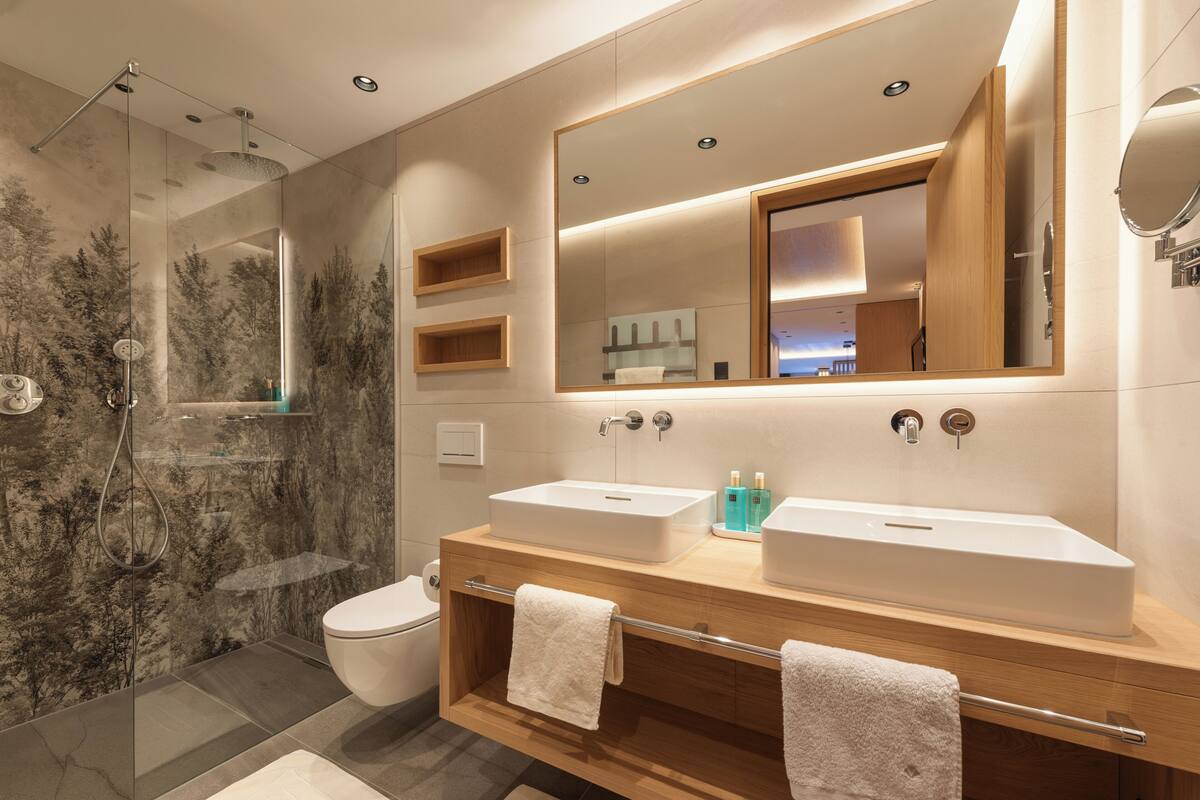 A modern bathroom with a glass-enclosed shower, two sinks, and a large mirror.