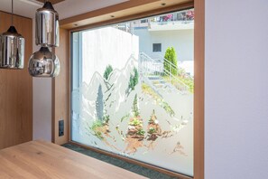 Una habitación con un ventanal grande, techo de madera y una mesa.