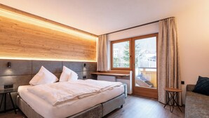 Une chambre moderne avec un grand lit, un bureau et une vue sur l’extérieur.