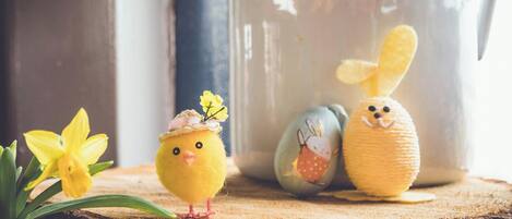 Una superficie de madera con un pollito amarillo, un conejo y un narciso.