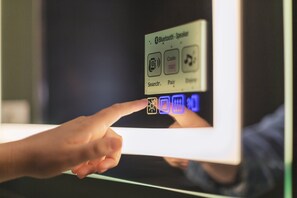 A hand interacting with a touchscreen interface on a device, displaying options like 'Bluetooth Speaker', 'Code', and 'Search'. - Holiday Inn - the niu, Dwarf Berlin Schöneberg by IHG (Berlin)