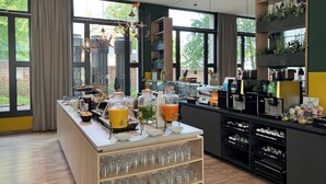 A breakfast bar with a variety of food and drink options, including jars of jam and a fruit bowl. - Holiday Inn - the niu, Dwarf Berlin Schöneberg by IHG (Berlin)