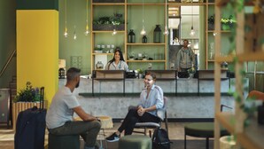 A modern reception area with a counter, seating, and a staircase. - Holiday Inn - the niu, Dwarf Berlin Schöneberg by IHG (Berlin)