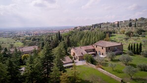 Eine ländliche Villa mit mehreren Gebäuden, umgeben von üppigem Grün und Bäumen.